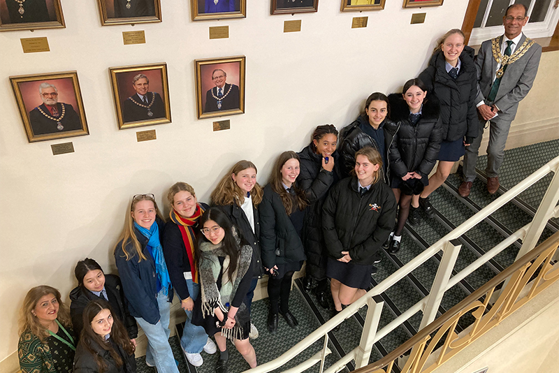 Wycombe Abbey pupils standing on a staircase with the Mayor of High Wycombe posing for a photo