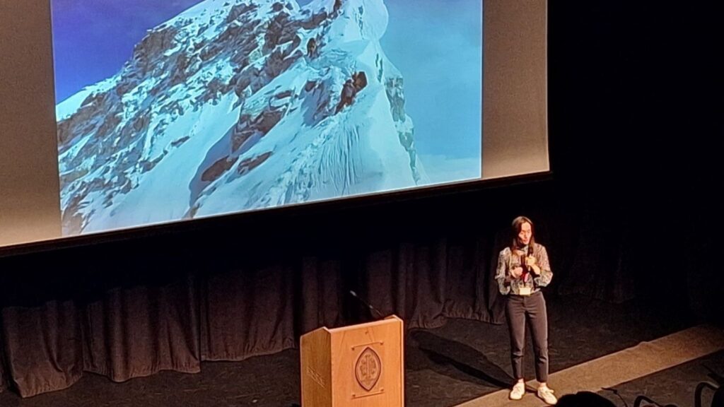Bonita Norris stood on stage in front of a slide that shows her climbing Mount Everest.
