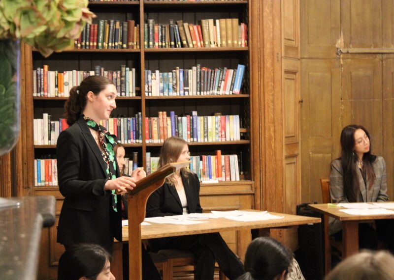 A pupil stood at a lectern with a disapproving look.