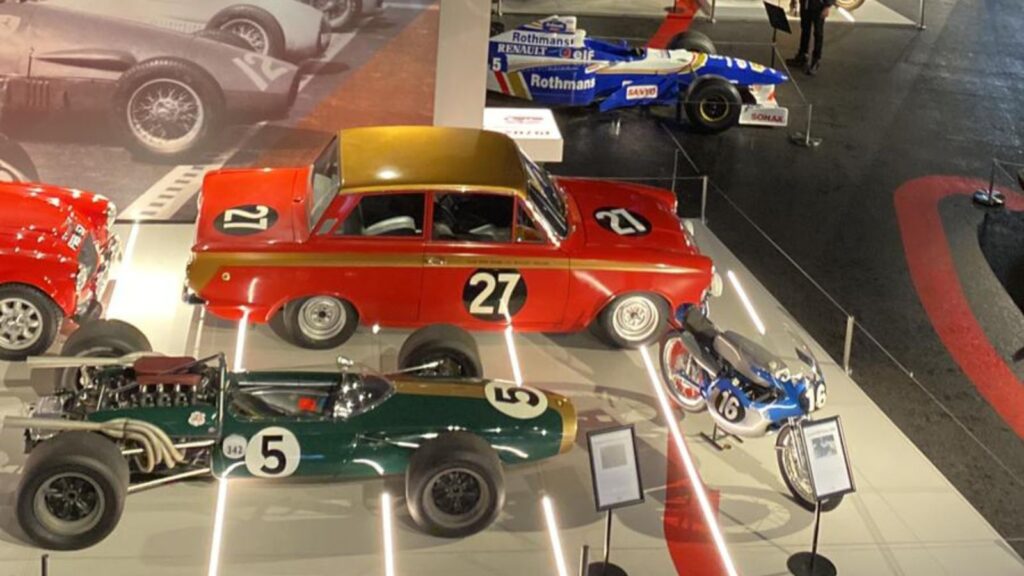 A blue model car, a green model car, and a blue model motorbike.