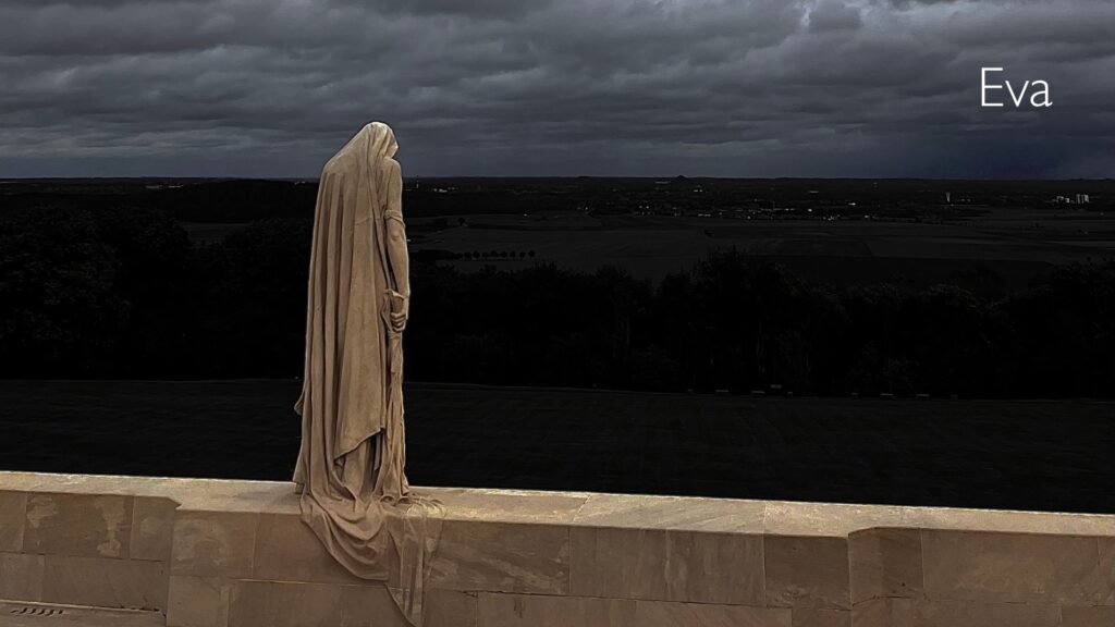 Eva's photo, which shows a statue wearing a sheet looking out into rolling fields at night.