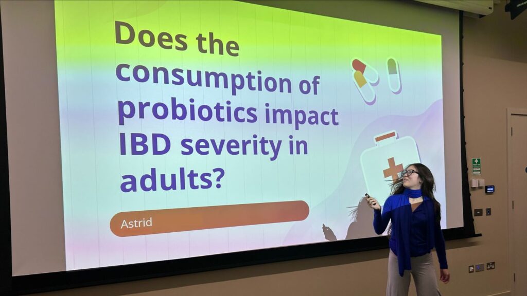 Astrid changing the slide on her presentation titled 'Does the consumption of probiotics impact IBD severity in adults?'