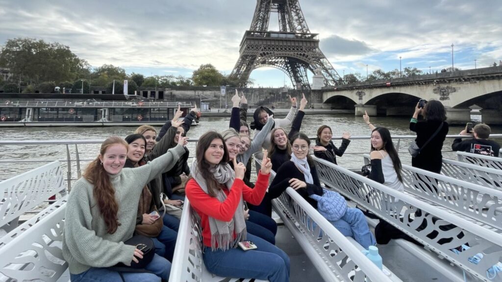 Pupils on a boat, pointing to the Eiffel Tower.