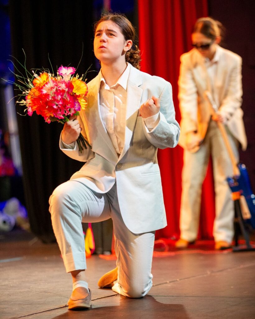 Wycombe Abbey pupil holding flowers whilst down on one knee.
