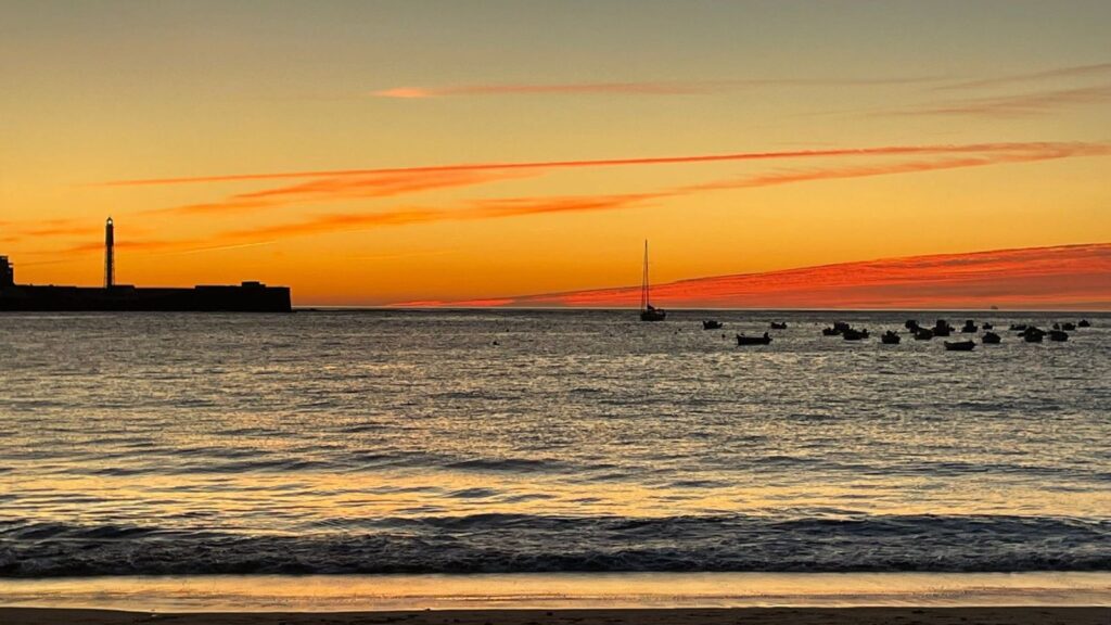 A picture of the sea and a beautiful pink and orange sunset.