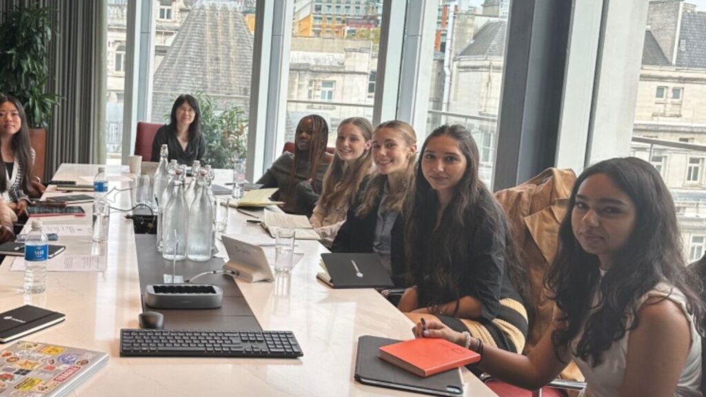 Wycombe Abbey pupils sat in a board room.