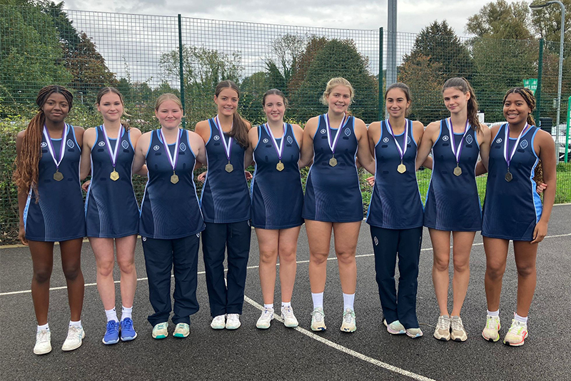 The Wycombe Abbey U19 Netball Team, smiling whilst wearing their gold medals.