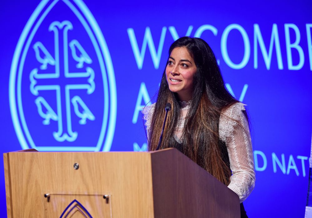 Lauren Monteil stood behind a Wycombe Abbey lectern, in front of the Wycombe Abbey MUN logo.