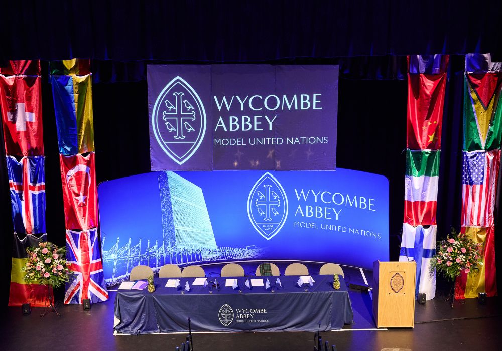 The Wycombe Abbey MUN logo surrounded by flags of different nations.