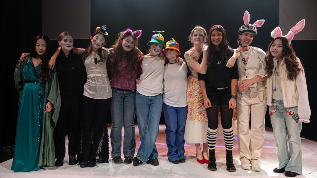 The cast of 'Alice' stood with their arms around one another.