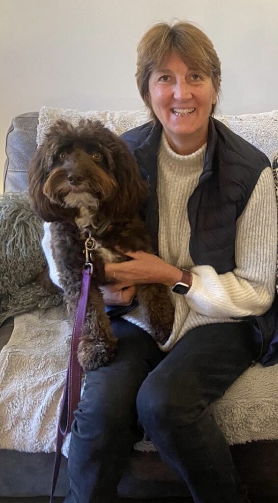 Rachel Keens sat on a sofa with her dog on her lap.