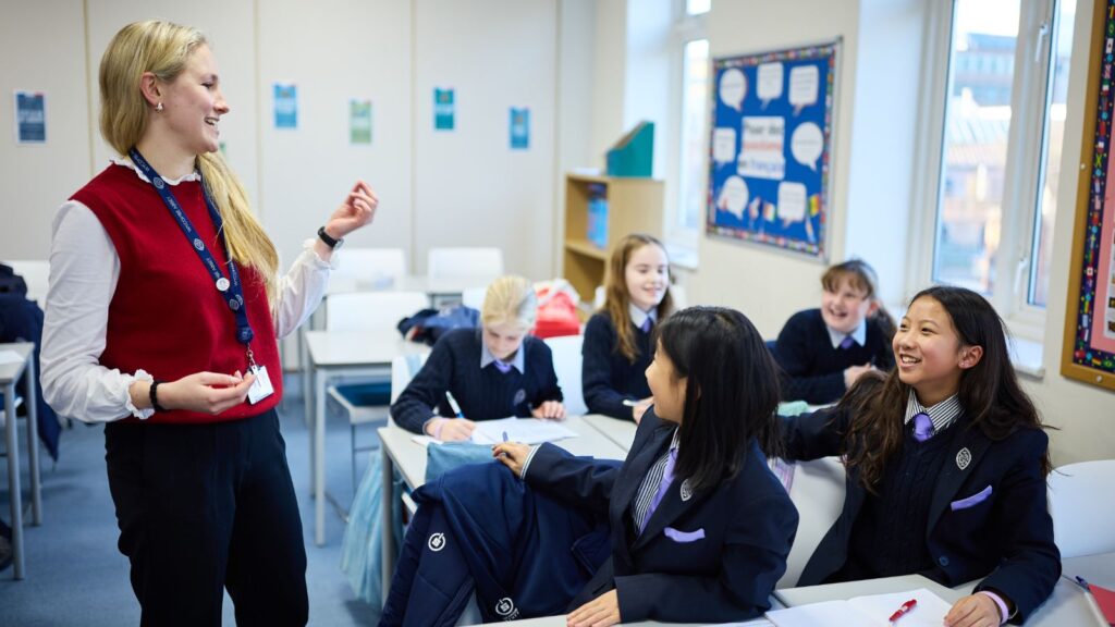 A teacher is talking to smiling pupils.