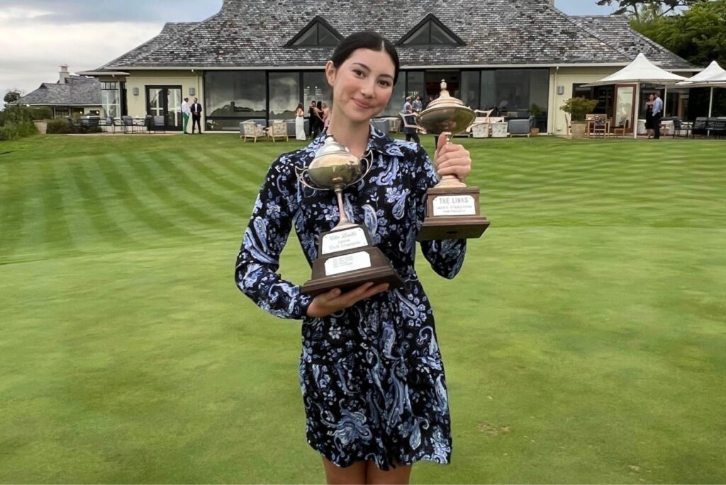 Serena smiling with two trophies.