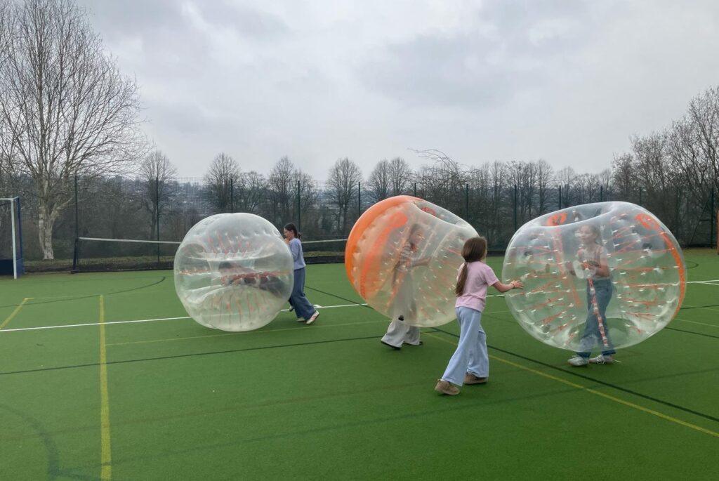 Girls doing body zorbing.