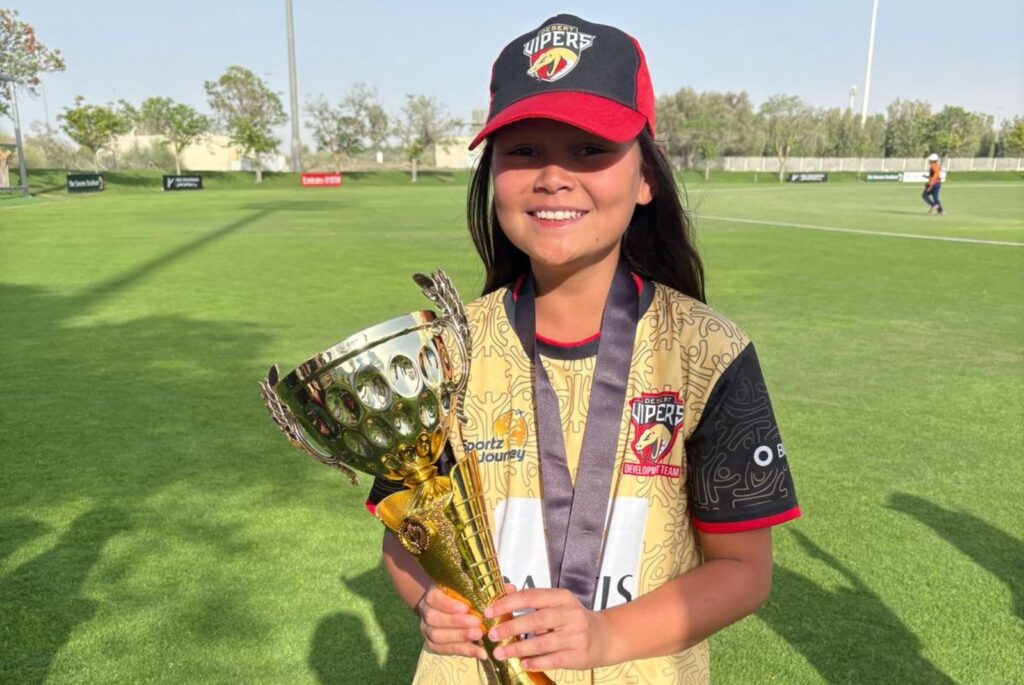 Ceci wearing a Vipers Cap, a gold medal, and holding her trophy.
