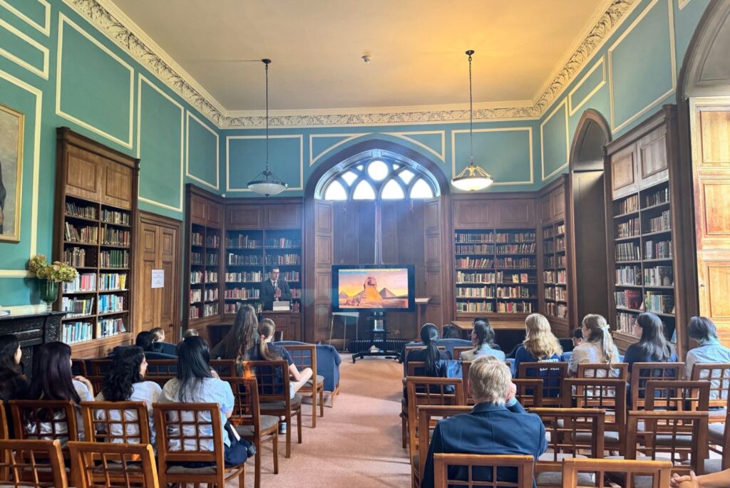 Mr Fitzgerald stood at the front of Fisher Library, next to his presentation.