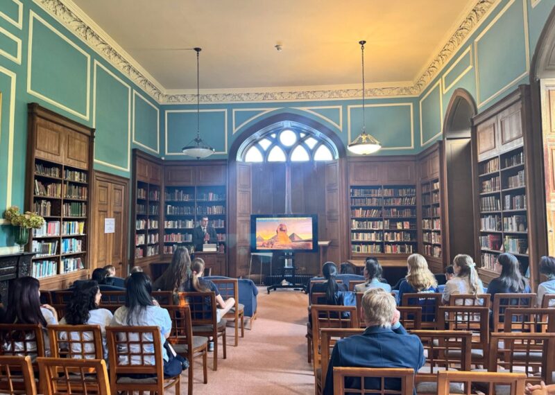 Mr Fitzgerald stood at the front of Fisher Library, next to his presentation.