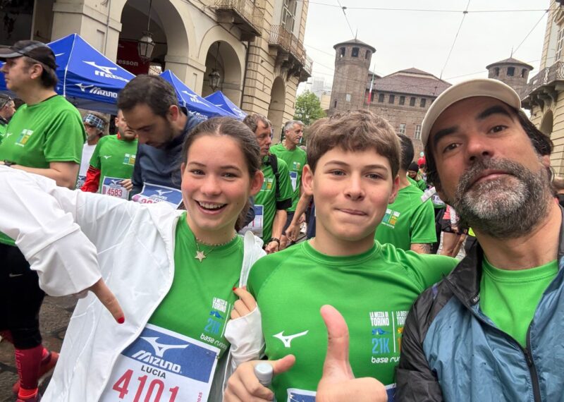 Lucia in her running clothes, stood next to her dad, with her arms closed.