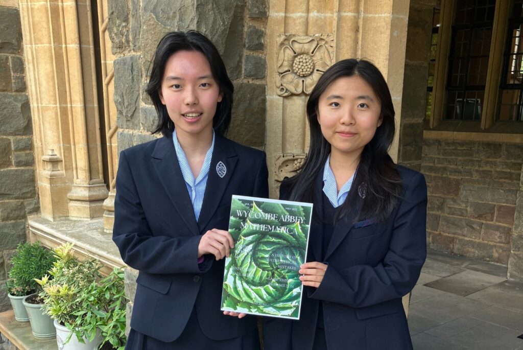 Cice and Judy holding a copy of Mathematica.