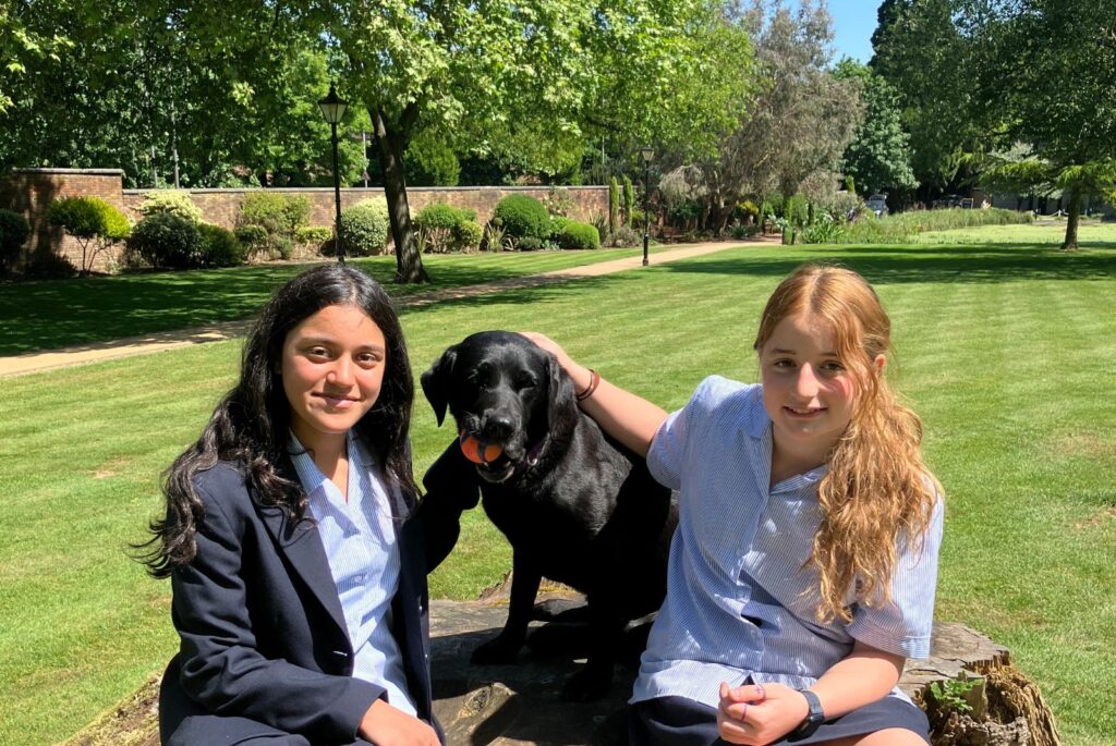 Isabella and Chiara sat either side of School therapy dog, Bella.