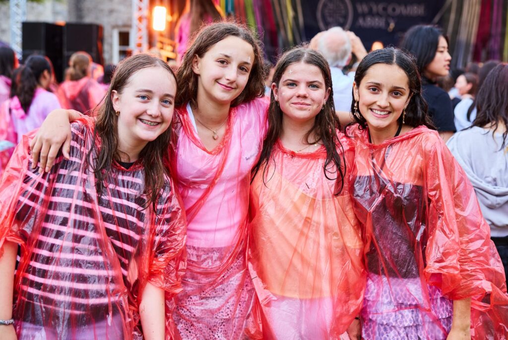 Four wet pupils in pink ponchos.