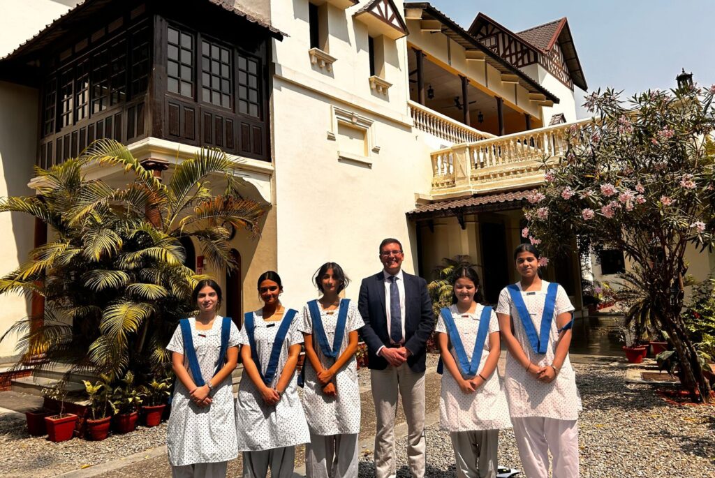 Nick stood outside Mussoorie International School with pupils.