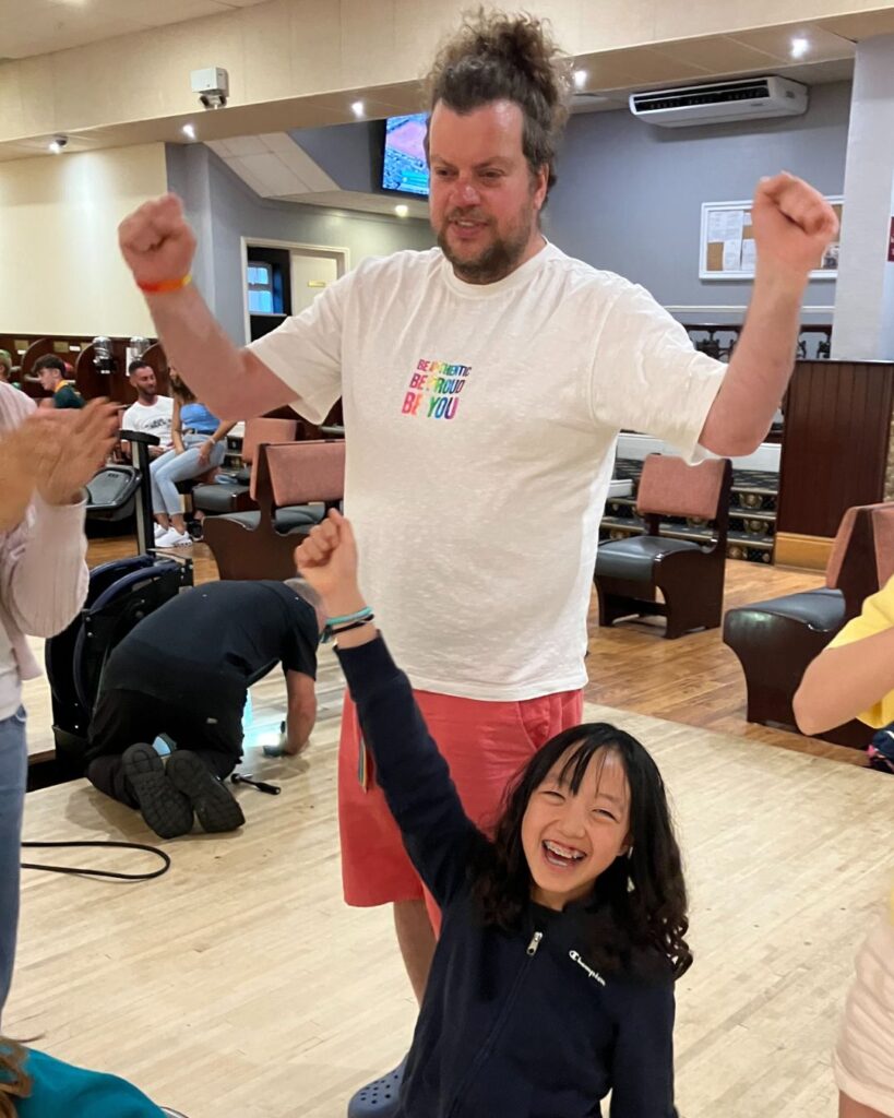 Mr Cadman and an UIII pupil cheering at the bowling alley.