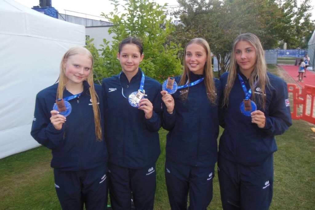 Annabelle and her relay team smiling with their bronze medals at the European Junior Swimming Championships.