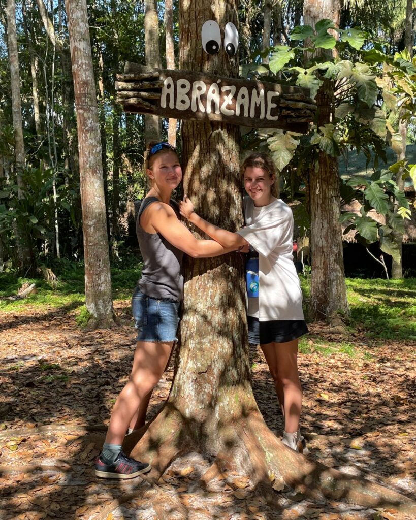 Two pupil hugging a tree