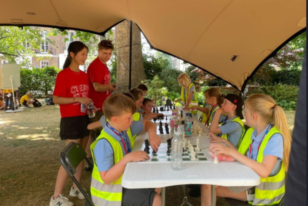 Emma and a fellow CSC ambassador coaching young children play chess.