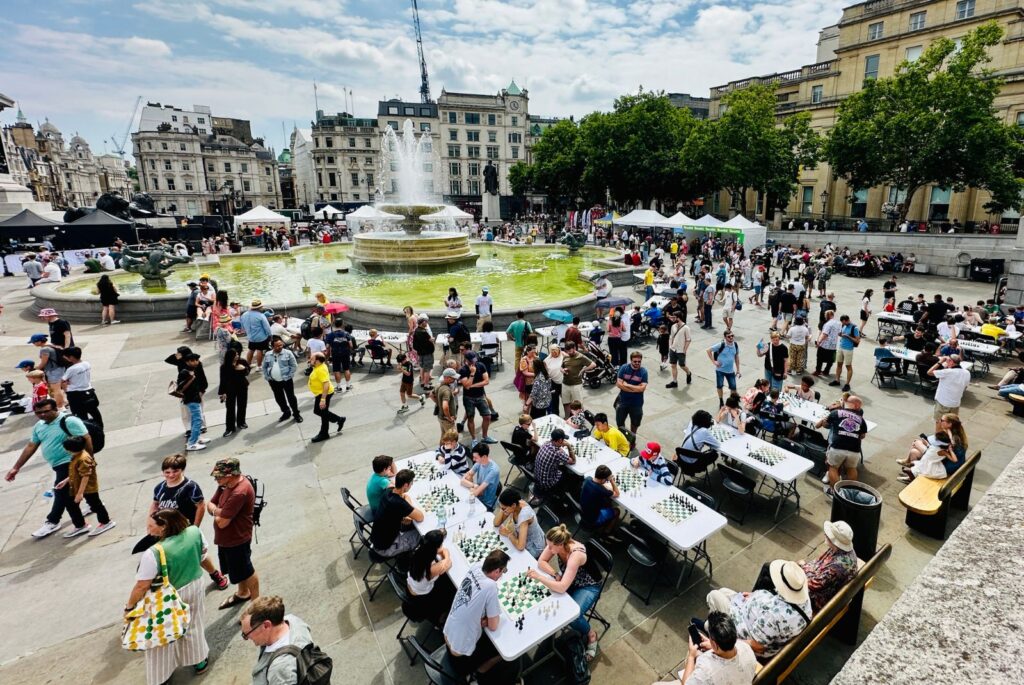 People sat at tables playing chess in Trafalgar Square