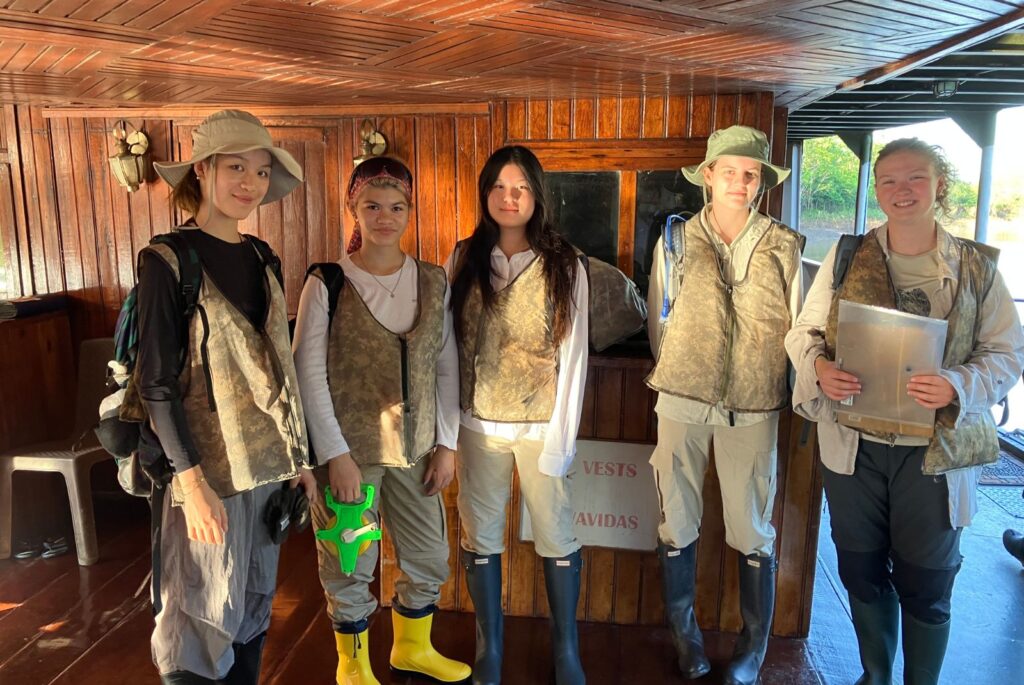 Pupils in jogging bottoms and camo gilets. Two are wearing bucket hats.