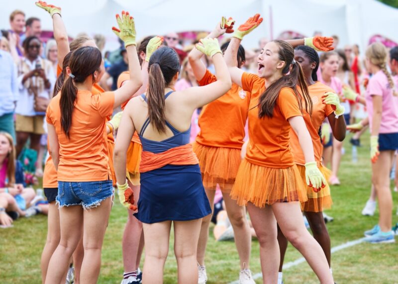 Group of Girls all dressed in orange high fiving
