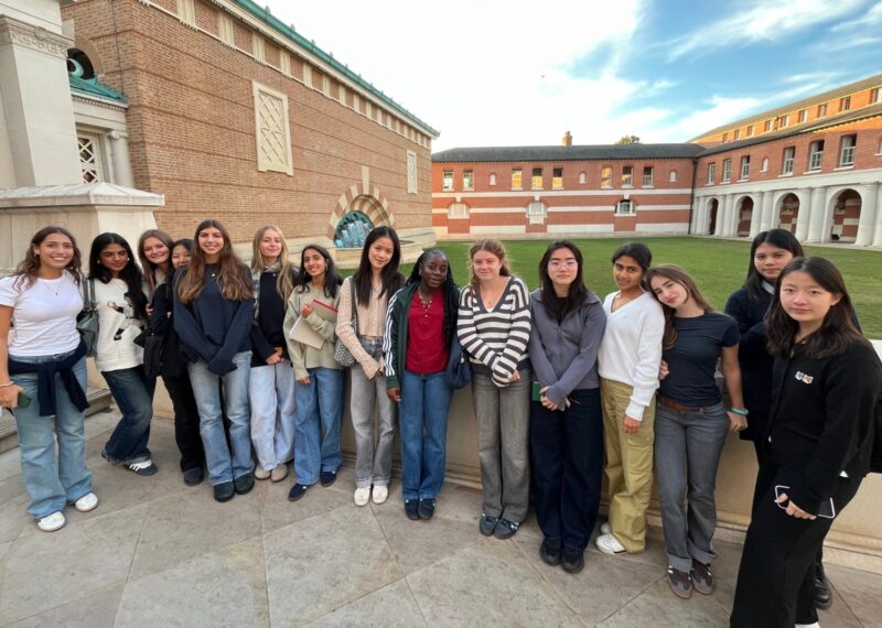 Group of girls stood in a line facing the camera outside Eton school.