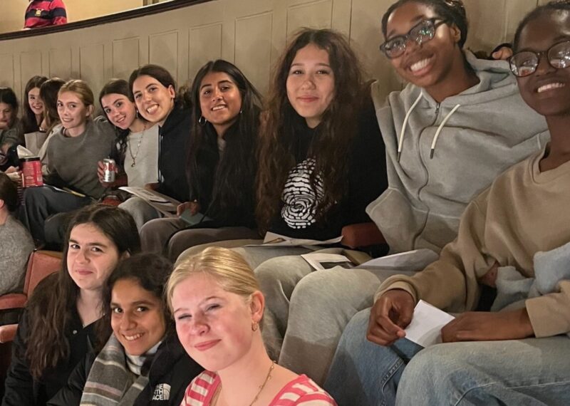 Group of girls at the theatre smiling to the camera