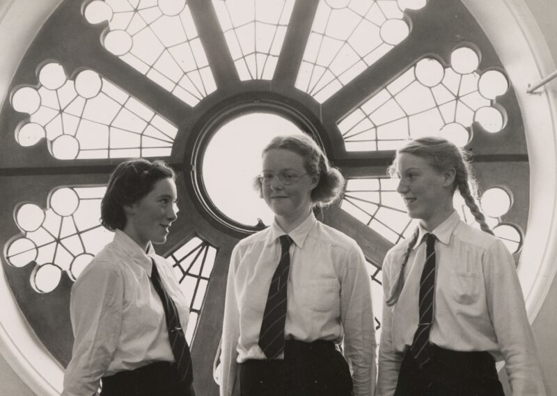 Old archived photo of Wycombe Abbey of three girls in fron tof the old round window