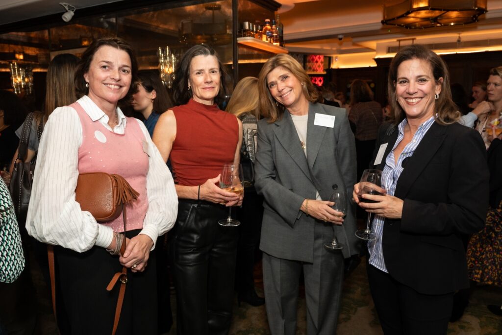 4 women stood smiling for the camera in a bar