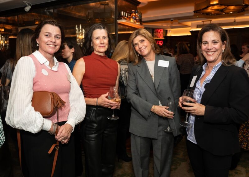 4 women stood smiling for the camera in a bar