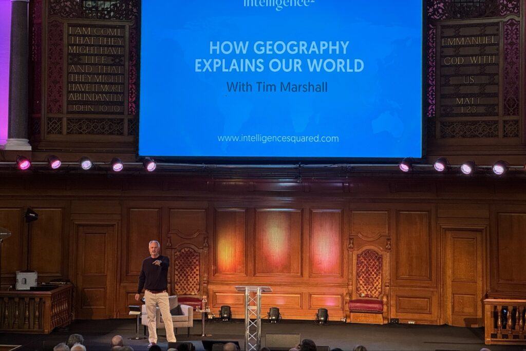 Man on stage doing a presentation