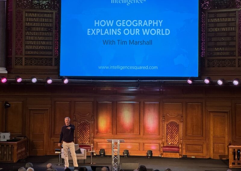 Man on stage doing a presentation