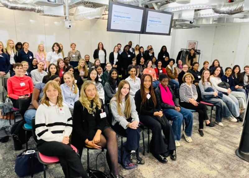 Group of girls sat in a room looking at the camera