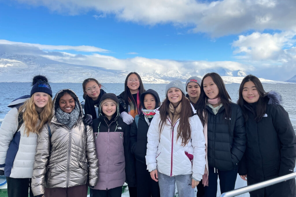 girls in group in winter wear standing in front of snowy background