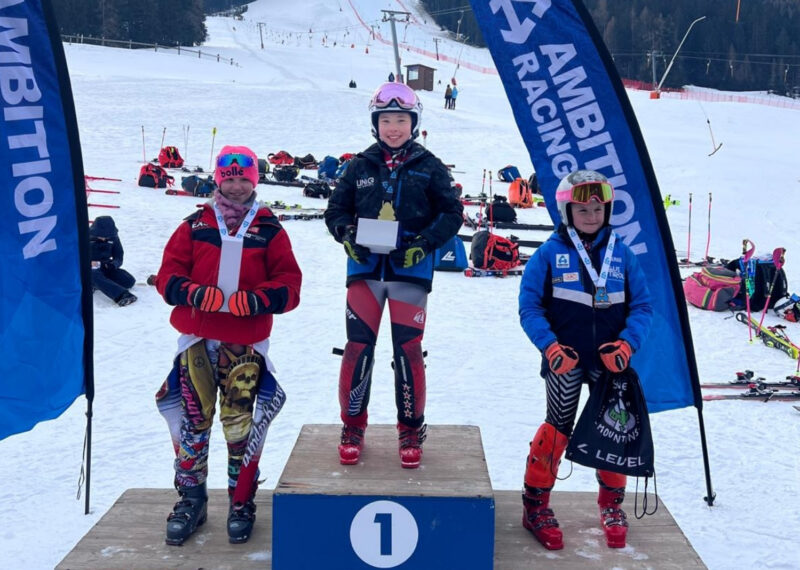 girl standing on a podium in first place at the ski slopes